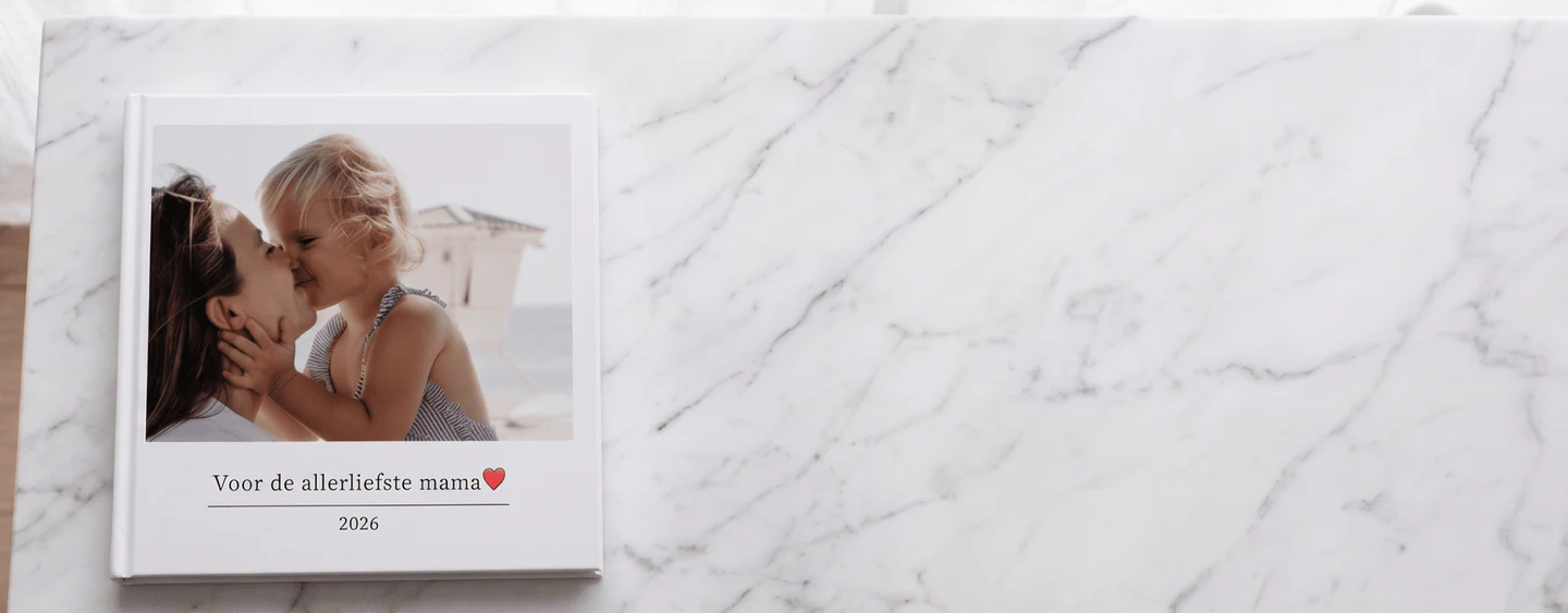 klikkie mother's day photo book held in two hands, family photos visible
