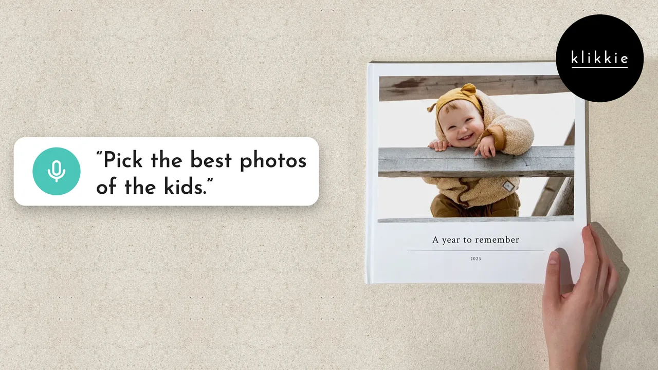 Una mano junto a un fotolibro Large de klikkie con un bebé riendo y “A year to remember” en la portada, con las palabras “Pick the best photos of the kids.”